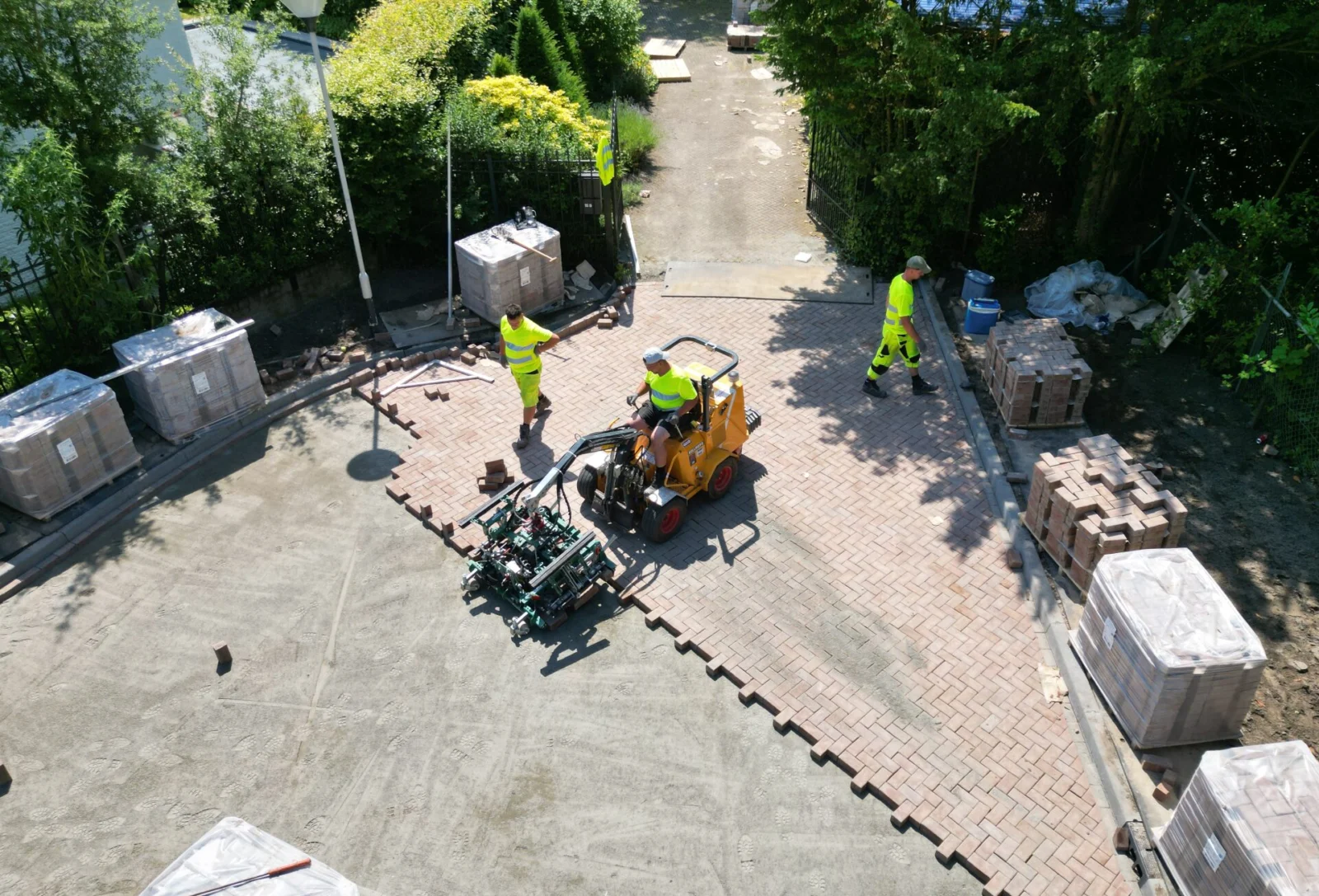 Machinale aanleg van bestrating in een woonstraat