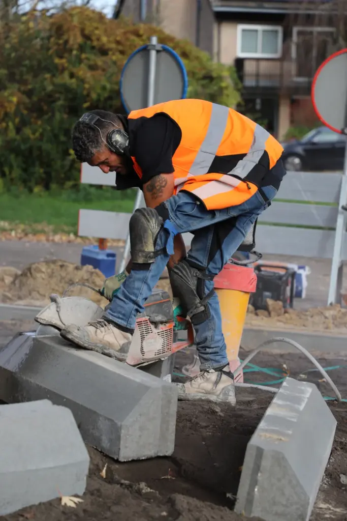 Stratenmaker zaagt een straatsteen op maat